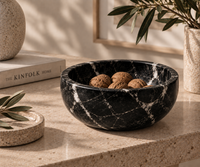 Black marble bowl styled as fruit bowl on dining table