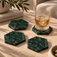Green marble coasters styled on dining table with glasses
