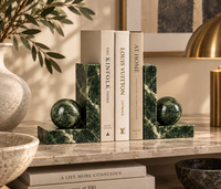Green marble bookends holding books on shelf