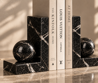 Black marble bookends holding books on shelf