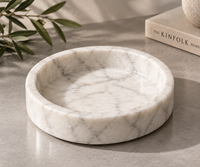 White marble catchall tray holding rings and jewelry