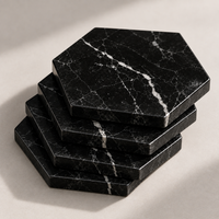 Stack of black marble hexagon coasters showing protective underside pads